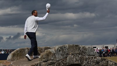 Tiger Woods acknowledges the fans as he walks over the Swilken Bridge. Reuters