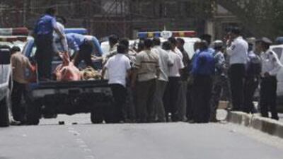 Iraqi police load victims killed in a bank robbery into a truck in central Baghdad, Iraq, on July 28, 2009.