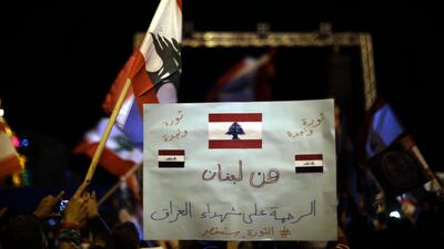 A Lebanese anti-government protester holds a placard readingin Arabic “From Lebanon to Iraq”, during a rally in the capital Beirut's downtown district. AFP