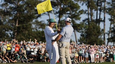 Rory McIlroy shakes hands with his caddie Harry Diamond after putting on the 18th green to win the 2026 Masters. EPA