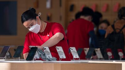 An employee cleans Apple iPhones at store in San Francisco, California. Bloomberg
