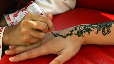 A tourist's hand is decorated with the traditional red dye at Heritage for Henna in Dubai yesterday.