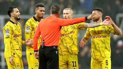 Dortmund players argue with referee Artur Dias. EPA