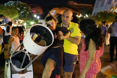 People look through telescopes at a viewing event put on by the Dubai Astronomy Group at Jebel Hafeet in Al Ain. Pawan Singh / The National