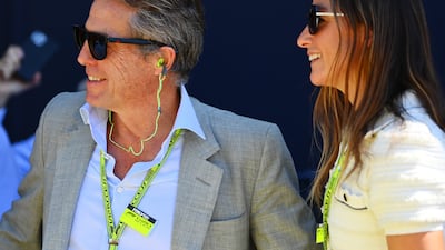 Actor Hugh Grant and Anna Elisabet Eberstein walk in the paddock. Getty