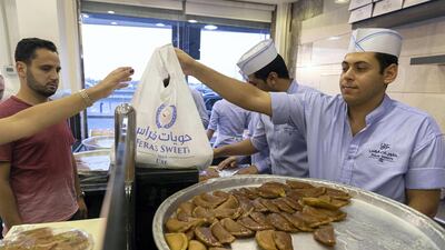 A Dubai vendor sells a selection of treats to a long queue of customers right before Iftar time until late in the evening. Antonie Robertson/The National