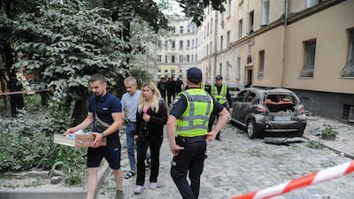 Residents leave the area of the attack in Lviv which left scores of people wounded. EPA