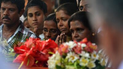 Mourners stand beside a coffin of a bomb blast victim. AFP