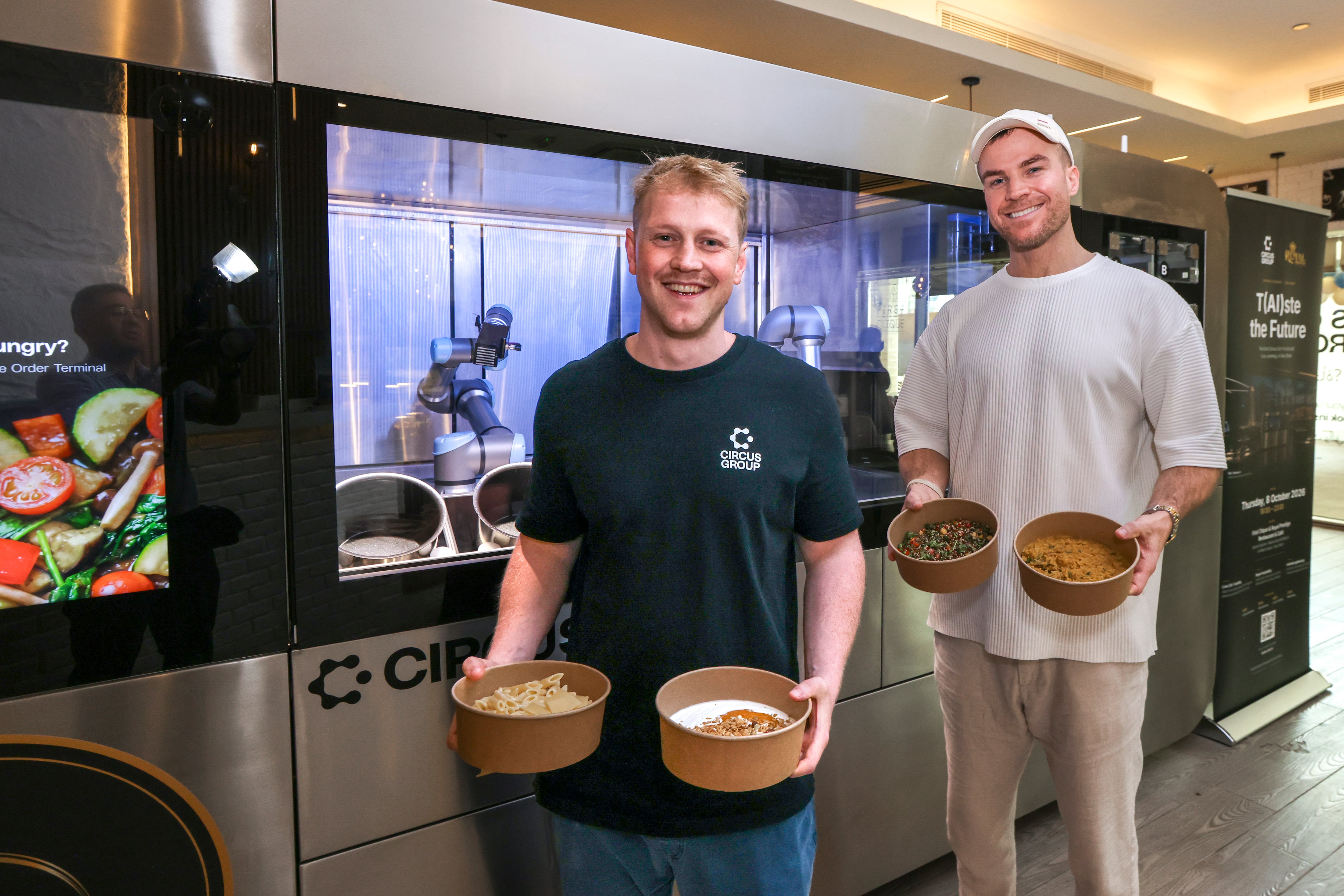 (L-R) Dylan Frayne and Michael Bassler with the CA-1, a fully autonomous, AI-powered robotic kitchen and meal-production system. Photo: Victor Besa / The National