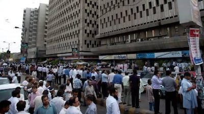 People evacuate buildings and gather on roads after a tremor from Iran’s earthquake was felt in Karachi. At least 34 Pakistanis were reported killed.