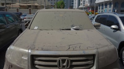 A Honda Pilot covered in dirt and slapped with tickets sits in a car park near World Trade Centre Mall in Abu Dhabi. Delores Johnson / The National