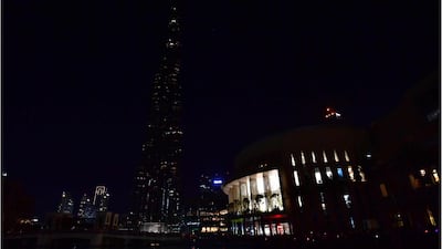This combination of pictures created on March 24, 2018 shows the Burj Khalifa skyscraper lit up and with the lights turned off during the earth hour environmental campaign in Dubai on March 24, 2018. Earth Hour, which started in Australia in 2007, is set to be observed by millions of supporters in 187 countries, who will turn off their lights at 8.30pm local time in what organisers describe as the world's "largest grassroots movement for climate change". / AFP PHOTO / Giuseppe CACACE