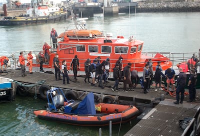 Iraqi, Iranian and Afghan migrants with two minors among their number are escorted off a French rescue vessel in Calais on Wednesday. AFP