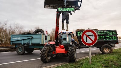 An effigy of a farmer hangs from the bucket of an agricultural telehandler, outside Paris, during a protest against government measures, including the culling of entire cattle herds, aimed at containing an outbreak of lumpy skin disease among livestock in France. AFP