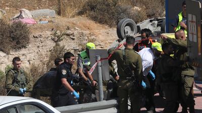 Israeli security and emergency services remove the body of a Palestinian driver who was shot dead after his car hit two Israelis near a settlement in the occupied West Bank, on August 17, 2019. AP Photo