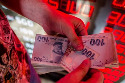 A money changer counts Turkish lira banknotes at a currency exchange office in Istanbul. AFP