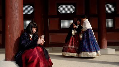 Tourists look at pictures after taking selfies in Seoul, South Korea. EPA