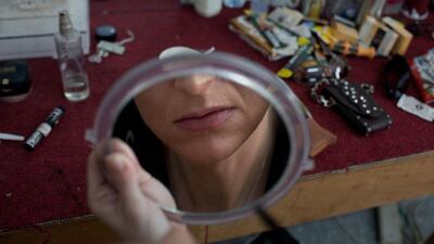 Beatrice Vallova of 'Bertini Sisters' and an assistant to her husband Jarosla Valla aka Jarda Ross' magic number, looks at herself in a mirror as she prepares for a performance.