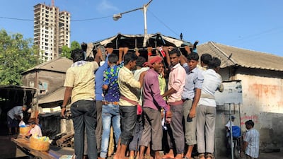 Indian workers travel on the back of a lorry in Mumbai. Punit Paranjpe / AFP