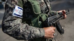 A member of the National Guard in Sweida, whose uniform displays the Israeli flag and a portrait of Druze leader Sheikh Hikmat Al Hijri. Hasan Belal for The National