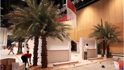 Workers set up stands for the Fourth International Date Palm Festival, opening today at the Abu Dhabi National Exhibition Centre.