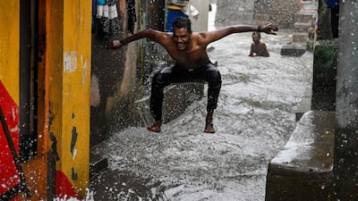 A man enjoys rain showers during high tide near the seafront in Mumbai. AFP