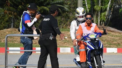 Mercedes-GP driver Lewis Hamilton is driven back to the pit, after his car caught fire during the Formula One Malaysian Grand Prix in Sepang on October 2, 2016. Manan Vatsyayana / AFP