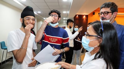 Staff giving sweets to Kabir Singh Pujji, left, and Bhumit Singh, centre, after they received they IB results at Gems Modern Academy at Nad Al Sheba in Dubai. All photos: Pawan Singh / The National