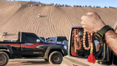 Dozens of drivers - pros and amateurs alike - try to make it up the 50-degree slipface. Victor Besa / The National