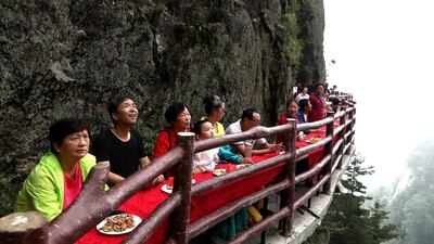 Tourists enjoy the view as they eat. AFP