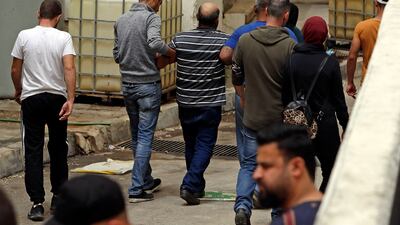 A grieving man is helped away at the entrance of the morgue of a hospital in Tripoli. AFP
