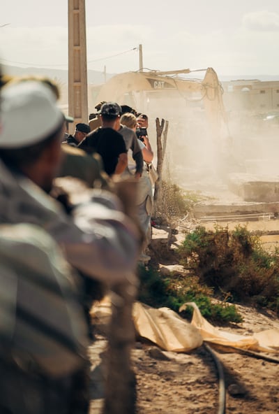 Locals and tourists watching heavy machinery destroy Imsouane , Morocco.