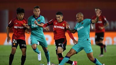 Takefusa Kubo of Mallorca battles for possession with Arthur Melo of Barcelona. Getty Images