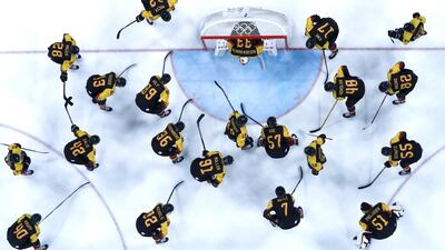 Germany players gather around their goalie Danny aus den Birken before the men's Ice Hockey preliminary round match between Germany and Norway at the Gangneung Hockey Centre. Larry Smith / EPA