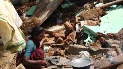 A resident of Hampi cooks amid the ruins of her home, which was demolished by authorities along with other residences and businesses in the main bazaar in July.