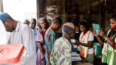 An official confirms the details of a voter at a polling station in Agege. AFP