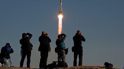 Onlookers take photographs as Russia’s Soyuz TMA-11M spacecraft carrying an unlit Olympic torch and an international crew including Japanese astronaut Koichi Wakata, Russian cosmonaut Mikhail Tyurin and US astronaut Rick Mastracchio blasts off from the Russian leased Kazakh Baikonur cosmodrome this morning. Kirill Kudryavtsev / AFP Photo
