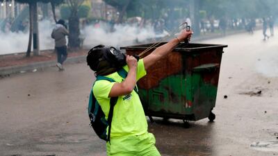 A protester hurls rocks with a slingshot during clashes with security forces near the Serail (headquarters of the Governorate), in the northern port city of Tripoli. AFP