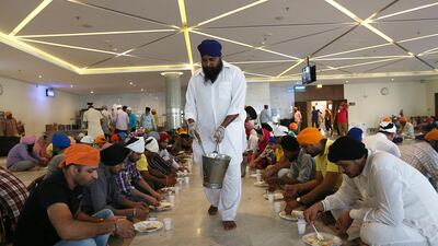 A Sikh chef at GuruNanak Darbar temple in Jebel Ali, Dubai, serves up meals to worshippers of all faiths. Christian churches and Sikh temples often join mosques in offering free meals during Ramadan. Satish Kumar / The National