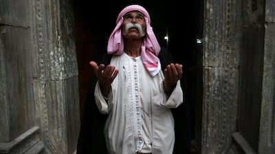 Sheikh Mirza, 84, prays at the entrance to the temple of Lalis, the most holy site of the Yazidi religion in Nineveh Province, Lalish, Iraq. John Moore / Getty Images