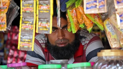 A man from the Rohingya community looks on as he sits inside his shop at a camp on the outskirts of Jammu. Reuters