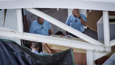 Members of the French gendarmerie carry a wooden box containing the wing part that was washed up on a beach, as they maneuver it into a van ready to be put onto a flight to France, at the Roland Garros Airport in Sainte-Marie, on the north coast of the Indian Ocean island of Reunion on July 31. Ben Curtis/AP Photo