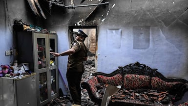 A police officer examines the scene of a deady fire at a care home in Batagoda, Sri Lanka. AFP
