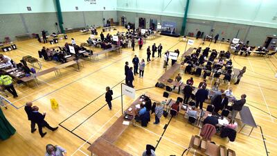 Volunteers sort ballot papers before counting at Basildon Sporting Village in Essex. PA