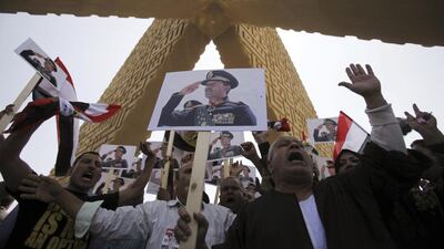 Supporters of the army hold posters of late Egyptian president Anwar Sadat as they protest against ousted Islamist president Mohammed Morsi and members of the Muslim Brotherhood at Sadat's tomb. Amr Abdallah / Reuters
