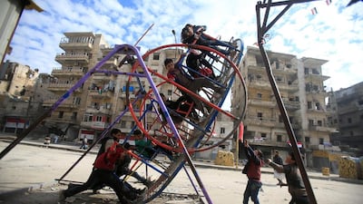 Children play on a swing in a damaged neighbourhood in Aleppo, Syria. Ali Hashisho / Reuters
