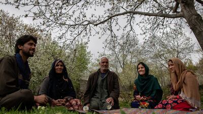Shekiba Kadir, second from right, sits with her family in their garden in Bektut village. Stefanie Glinski for The National