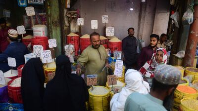People buy rice at a market in Karachi on February 3, 2023. - Pakistan's Prime Minister Shehbaz Sharif said February 3 the government would have to agree to IMF bailout conditions that are "beyond imagination", as it battles a spiralling economic crisis. (Photo by Asif HASSAN / AFP)