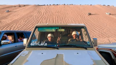 Spectators in an off-roader at the base of the Moreeb dune. Thousands drive out to the remote Empty Quarter for a thrilling two weeks of culture and racing action alike. Victor Besa / The National