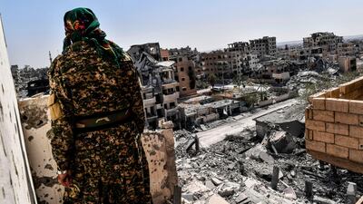 A member of the Syrian Democratic Forces (SDF), backed by US special forces, monitors the area on the western front line in Raqqa on October 8, 2017. Bulent Kilic / AFP